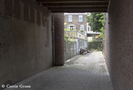 Letters ('Huis') in de poort, met links achter een werk-opslagplaats.
<br/>
Corrie Groen- Pickhard, 2015-06-24
